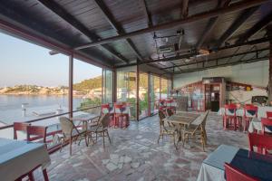 un restaurante con mesas y sillas y vistas al agua en Hayalbaz, en Izmir