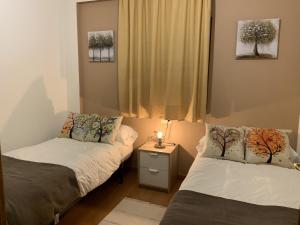 Habitación pequeña con 2 camas y una mesita de noche en Apartamentos Los Lagos, en Benasque