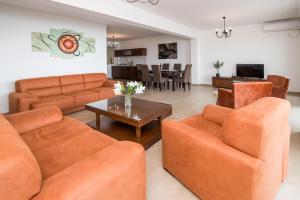 sala de estar con sofás naranjas y mesa en Arabela 2 Apartments, en Utjeha