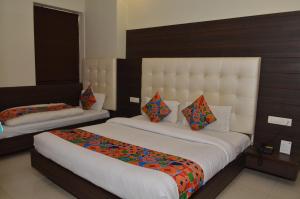 a hotel room with two beds with colorful pillows at Hotel KK Continental 50 Meter from Railway Station - Amritsar in Amritsar