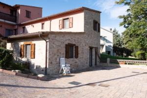 a small stone house with a chair in front of it at B&B da Vi.Vì in Urbania