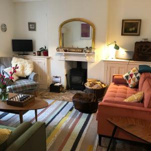a living room with a couch and a fireplace at Fernleigh Cottage in Boscastle