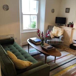 a living room with a green couch and a coffee table at Fernleigh Cottage in Boscastle