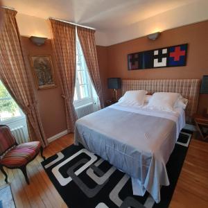 a bedroom with a large bed and a chair at SUPREMATISME Appartement de Prestige in Vierzon