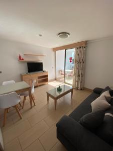 a living room with a couch and a table at Apartamentos Oasis Sol in Maspalomas