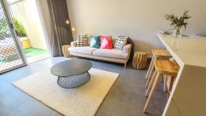 a living room with a couch and a table at Il Palazzo Holiday Apartments in Cairns