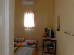 a room with a bed and a desk and a window at Hotel Musafir Inn in Padang +72 photos