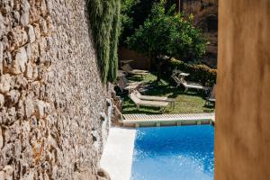 a stone wall with a swimming pool in a yard at Amalfi Resort in Amalfi