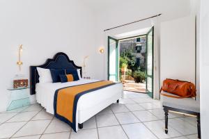 - une chambre avec un grand lit et un balcon dans l'établissement Amalfi Resort, à Amalfi