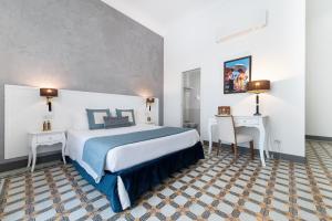 a bedroom with a large bed and two tables and a desk at Amalfi Luxury House in Amalfi
