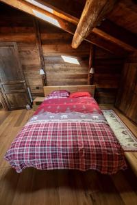 a bedroom with a red bed in a attic at Baita di charme con vista meravigliosa in Verrayes