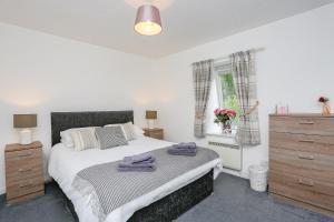 1 dormitorio con 1 cama, vestidor y ventana en 6 Beech Court en Dunblane