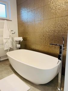 普福爾茨海姆的住宿－Apartment Am Kupferhammer，浴室内设有大型白色浴缸。