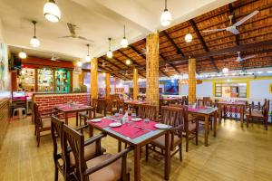 a dining room with tables and chairs in a restaurant at Spazio Leisure Resort, Goa in Anjuna