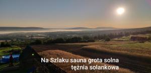 a view of a field with the sun in the sky at Noclegi u Banysia w sercu Gór Świętokrzyskich in Krajno Pierwsze