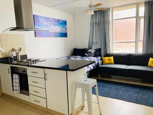 Il comprend une petite cuisine et un salon avec un canapé. dans l'établissement 605 Tenbury Beach Apartment, à Durban