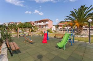 - une aire de jeux avec des toboggans et des bancs colorés dans un parc dans l'établissement Saint George's Hotel, à Nea Stira