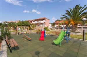a playground with colorful slides and benches in a park at Saint George's Hotel in Nea Stira