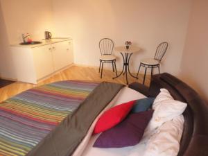 un letto in una stanza con sedie e tavolo di Capital Riga Apartment - Raiņa Boulevard a Riga