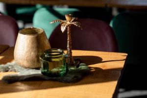 a table with a palm tree figurine and a jar on it at Casa Cava B&B in Dendermonde
