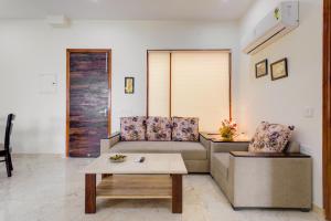 een woonkamer met een bank en een salontafel bij Hostie Eva Dreams - Private 2 BHK Apartments near Artemis, Medanta, Fortis hospitals in Gurgaon