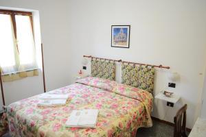 - une chambre dotée d'un lit avec un couvre-lit floral dans l'établissement Cantina Dell'Arte, à Ascoli Piceno