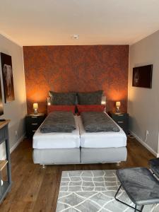 a bedroom with two beds and a wall with orange wallpaper at Forsternest in Hameln