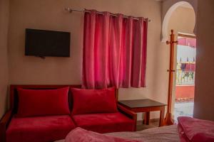 ein Wohnzimmer mit einem roten Sofa und einem Fenster in der Unterkunft Hotel Atlas in Aguim
