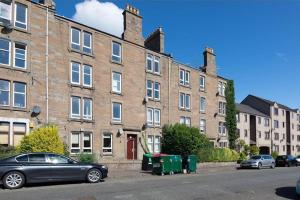 a car parked in front of a large brick building at ☆ Bright, 2 Bedroom West End Apartment ☆ in Dundee