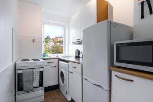 eine Küche mit einem Kühlschrank und einer Mikrowelle in der Unterkunft ☆ Bright, 2 Bedroom West End Apartment ☆ in Dundee