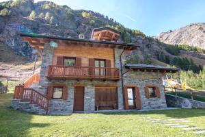 una casa di tronchi con terrazza su una montagna di Chalet Mountain Relax - CIR 0001 a Rhêmes-Notre-Dame