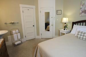 a bedroom with a bed and a sink and a mirror at Fullerton Inn & Restaurant in Chester