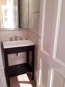 uma casa de banho com um lavatório e um espelho em Casa mia em Mar del Plata