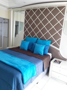 a bedroom with a large bed with blue pillows at Into The Blue on the Beach in Durban