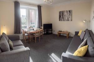 a living room with a couch and a table at ☆Spacious Flat Close to University and City Centre in Dundee
