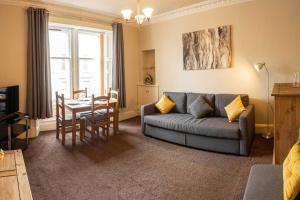 a living room with a couch and a table at ☆ Central, Spacious Apartment Close to University☆ in Dundee