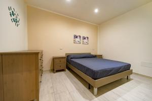 a bedroom with a bed and a wooden dresser at Naranji House Blue - Relax in Altavilla Milicia