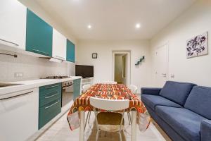 a kitchen with a table and a blue couch at Naranji House Blue - Relax in Altavilla Milicia