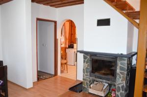 a living room with a stone fireplace and a doorway at Chata Zofka in Ižipovce