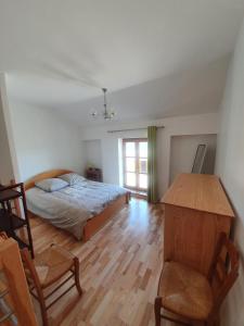 1 dormitorio con 1 cama, mesa y sillas en Gîte Le Bonnet en Marlieux