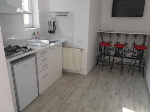 a kitchen with white cabinets and a counter with stools at Spirii house in Braşov