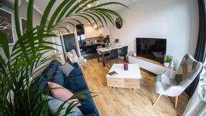 uma sala de estar com um sofá azul e uma mesa em Apartamenty Baltica Towers Modern White&Black em Gdansk
