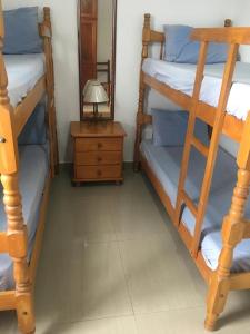 2 Etagenbetten in einem Zimmer mit einer Lampe und einem Spiegel in der Unterkunft Apartamento 3 quartos de cobertura na Praia Grande em Ubatuba in Ubatuba
