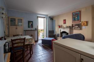 una cucina e un soggiorno con tavolo e camino di Appartamento VillaGiò - Terrazzo a Stresa