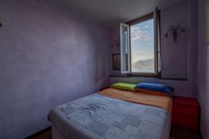 una piccola camera con letto e finestra di Appartamento VillaGiò - Terrazzo a Stresa
