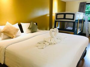 a large white bed with a towel on it at Baan Sang Singh in Chiang Mai