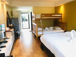 a hotel room with two beds and a desk and a room with two beds at Baan Sang Singh in Chiang Mai