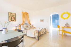 a bedroom with a bed and a table and a desk at Saint George's Hotel in Nea Stira