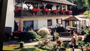 un modèle de maison avec des fleurs sur le balcon dans l'établissement Zum Herrenwald, à Stadtallendorf