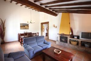 a living room with a blue couch and a fireplace at Casas de Cantoblanco in Viñuela
